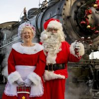 Santa and Mrs. Clause in front of train